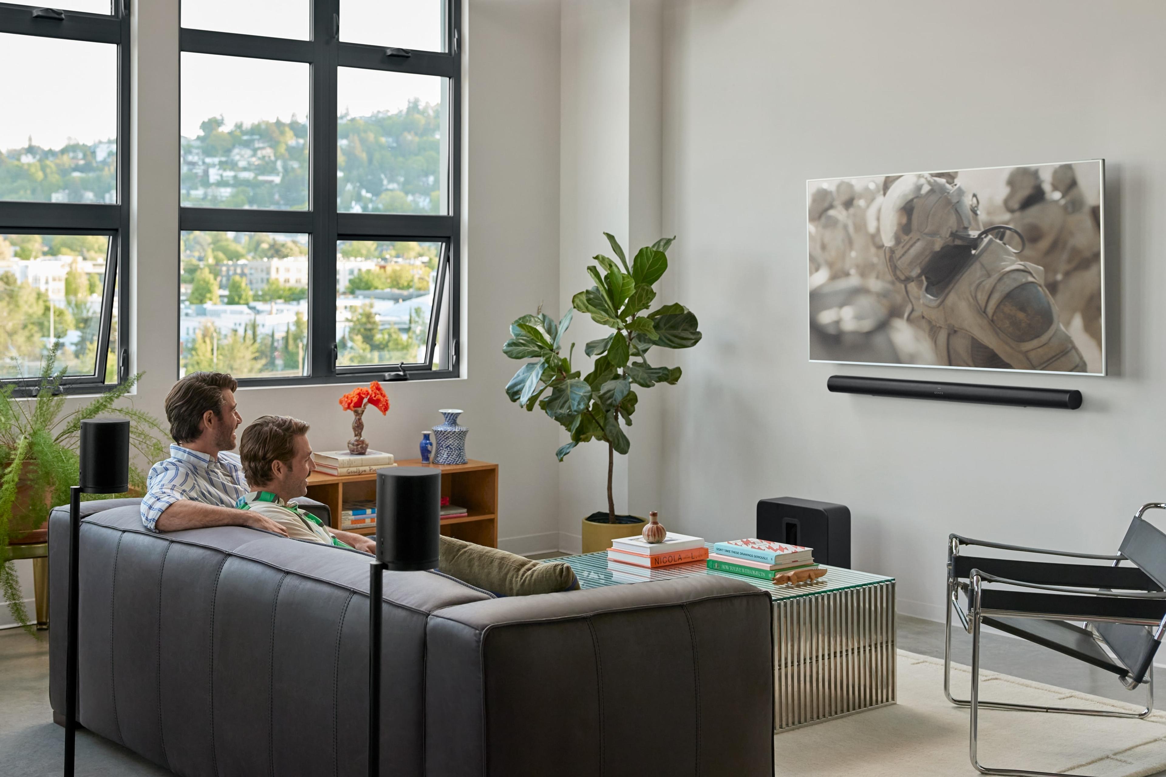 Two people sitting on the couch watching Dune 2 with a Arc Ultra home theater system