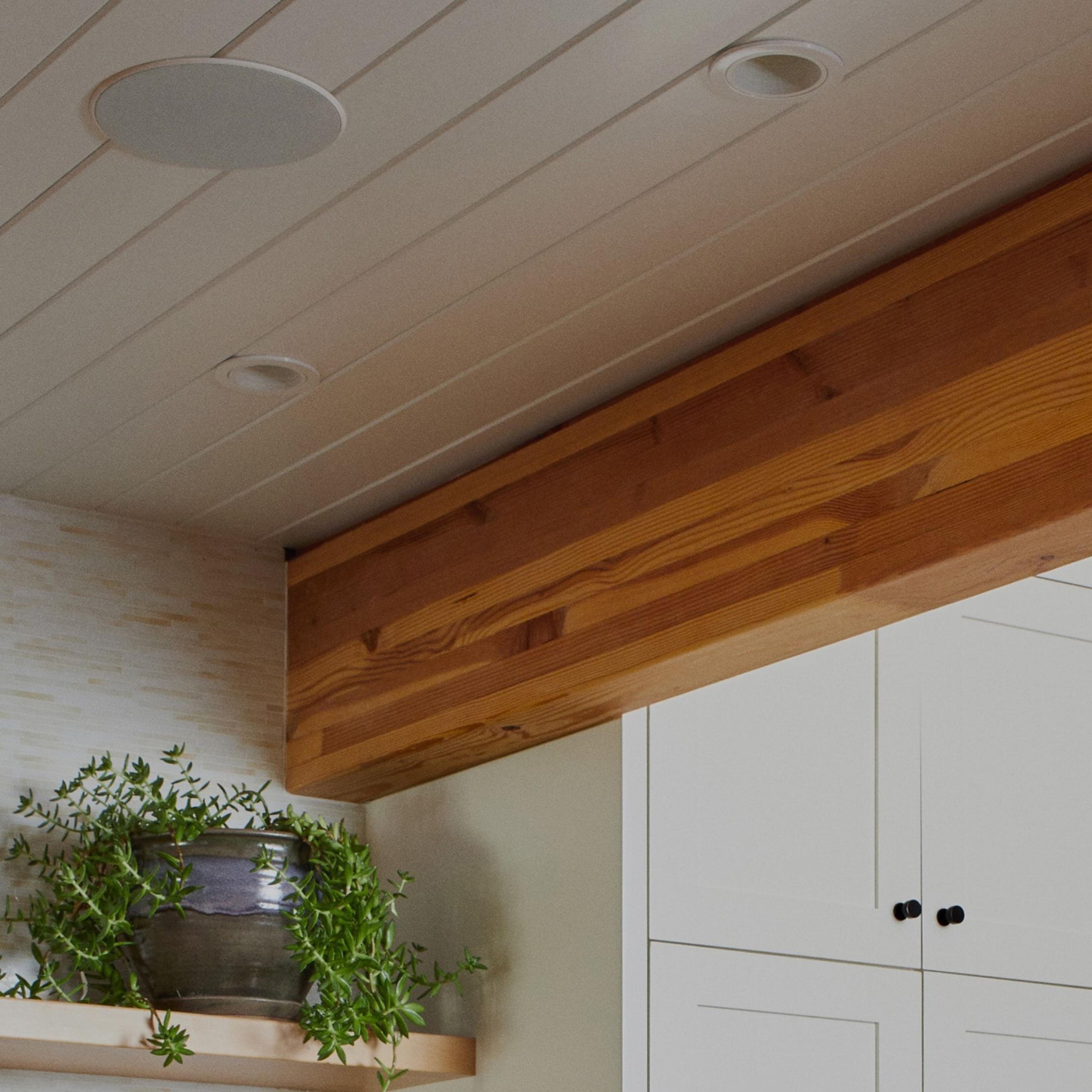 Closeup of Sonos and Sonance In-Ceiling speaker installed in ceiling above shelving