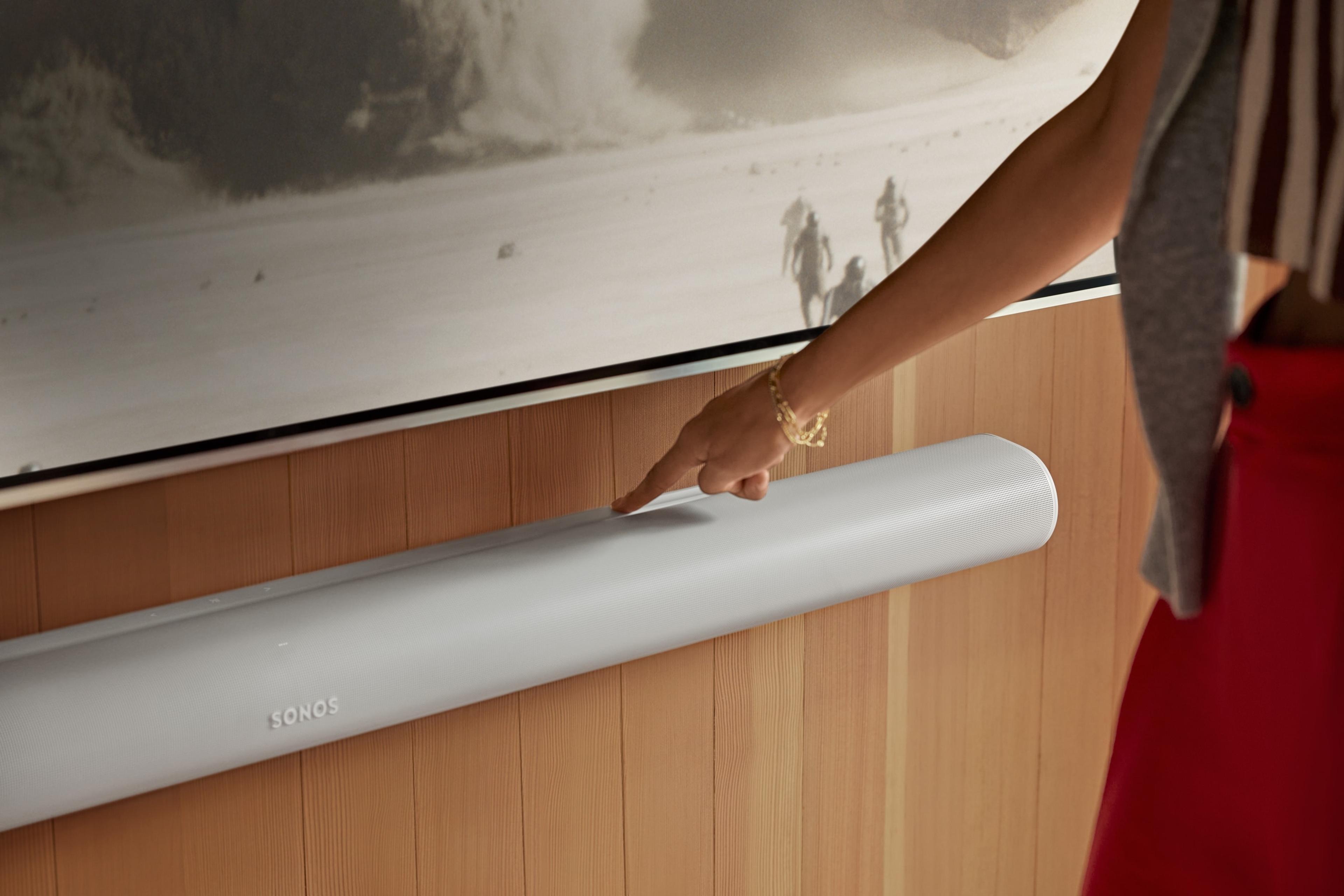 User engaging with the touch controls on a wall-mounted, white Arc Ultra