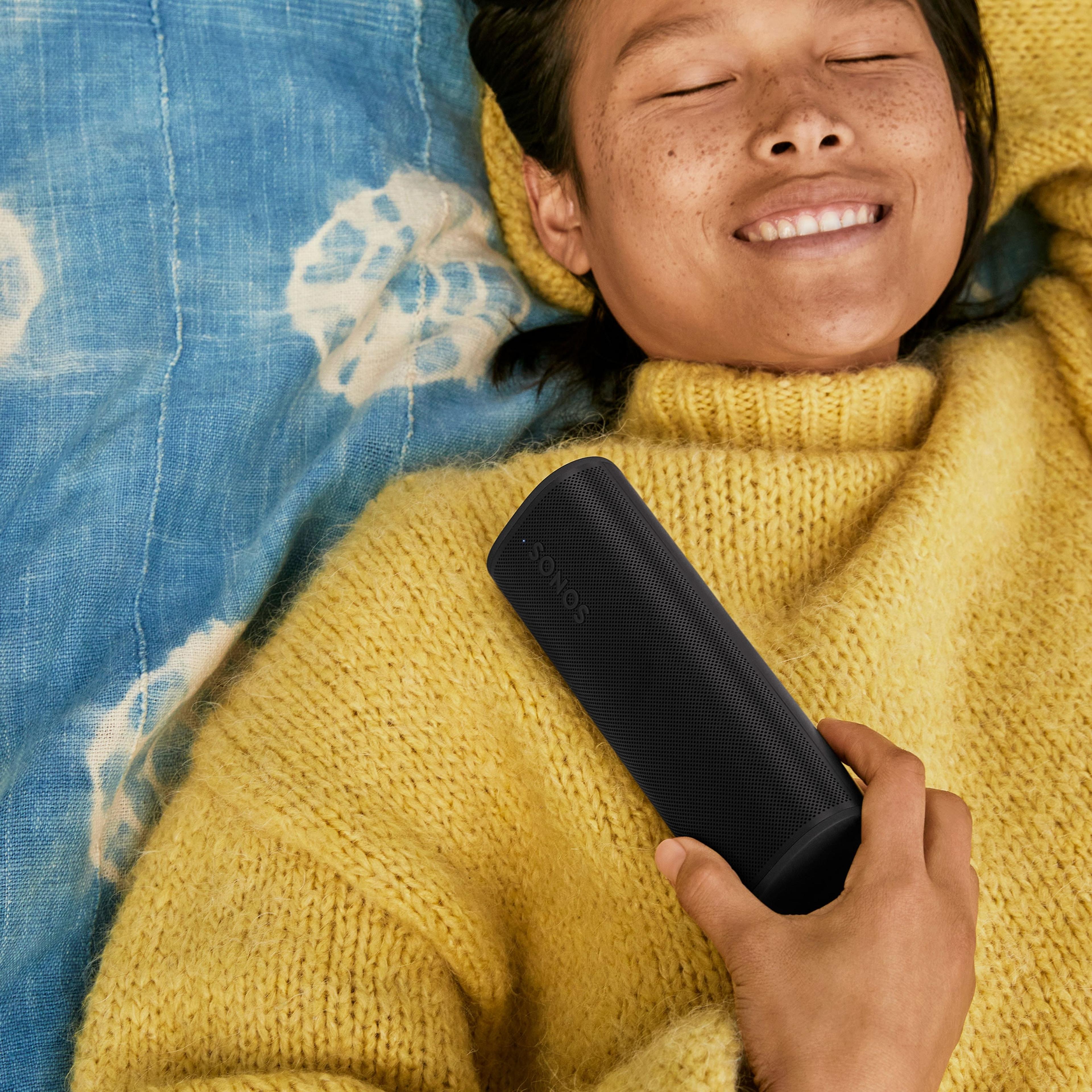 Person smiling and holding Roam 2 black