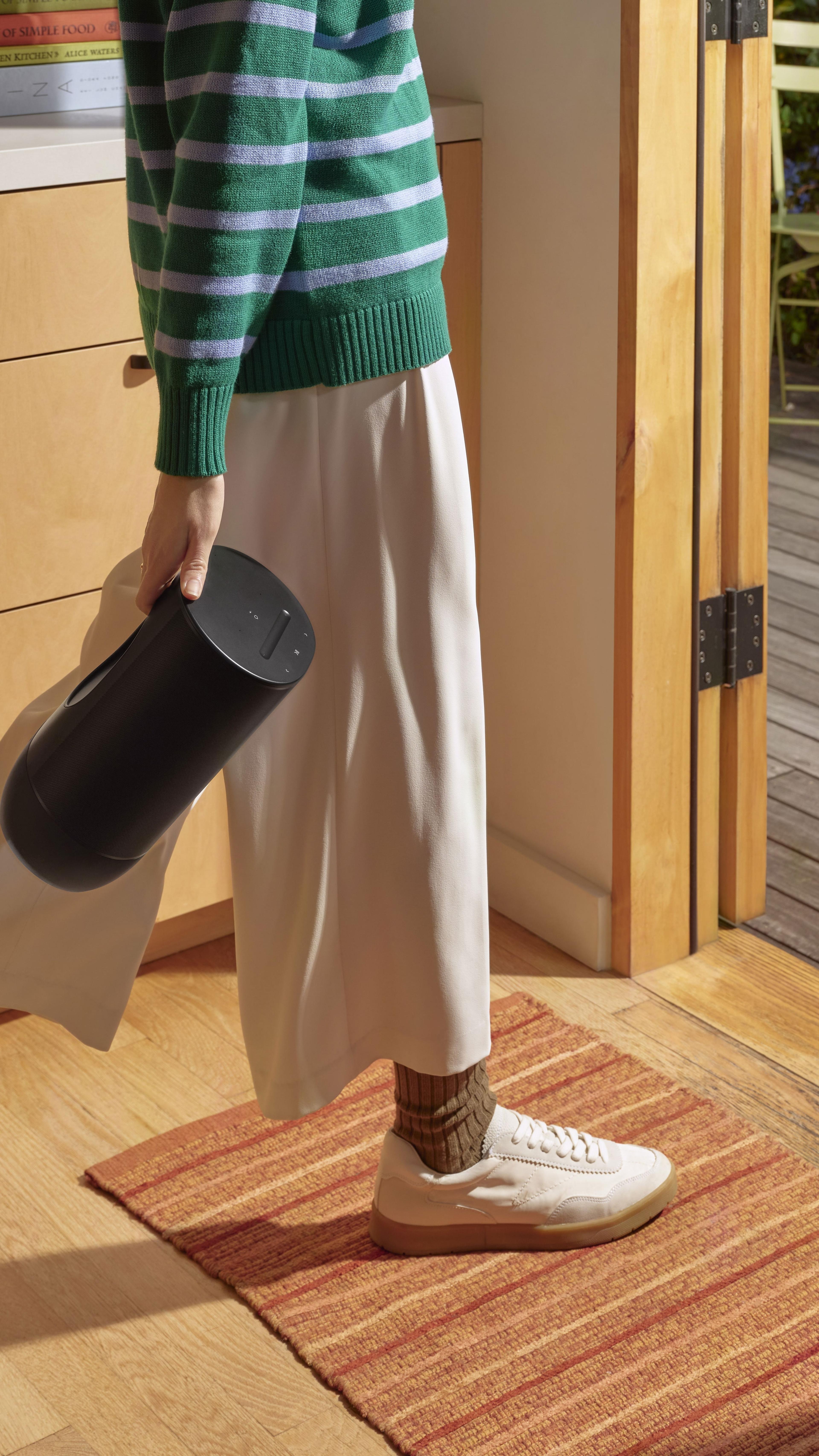 Person walking holding a black Sonos Move 2