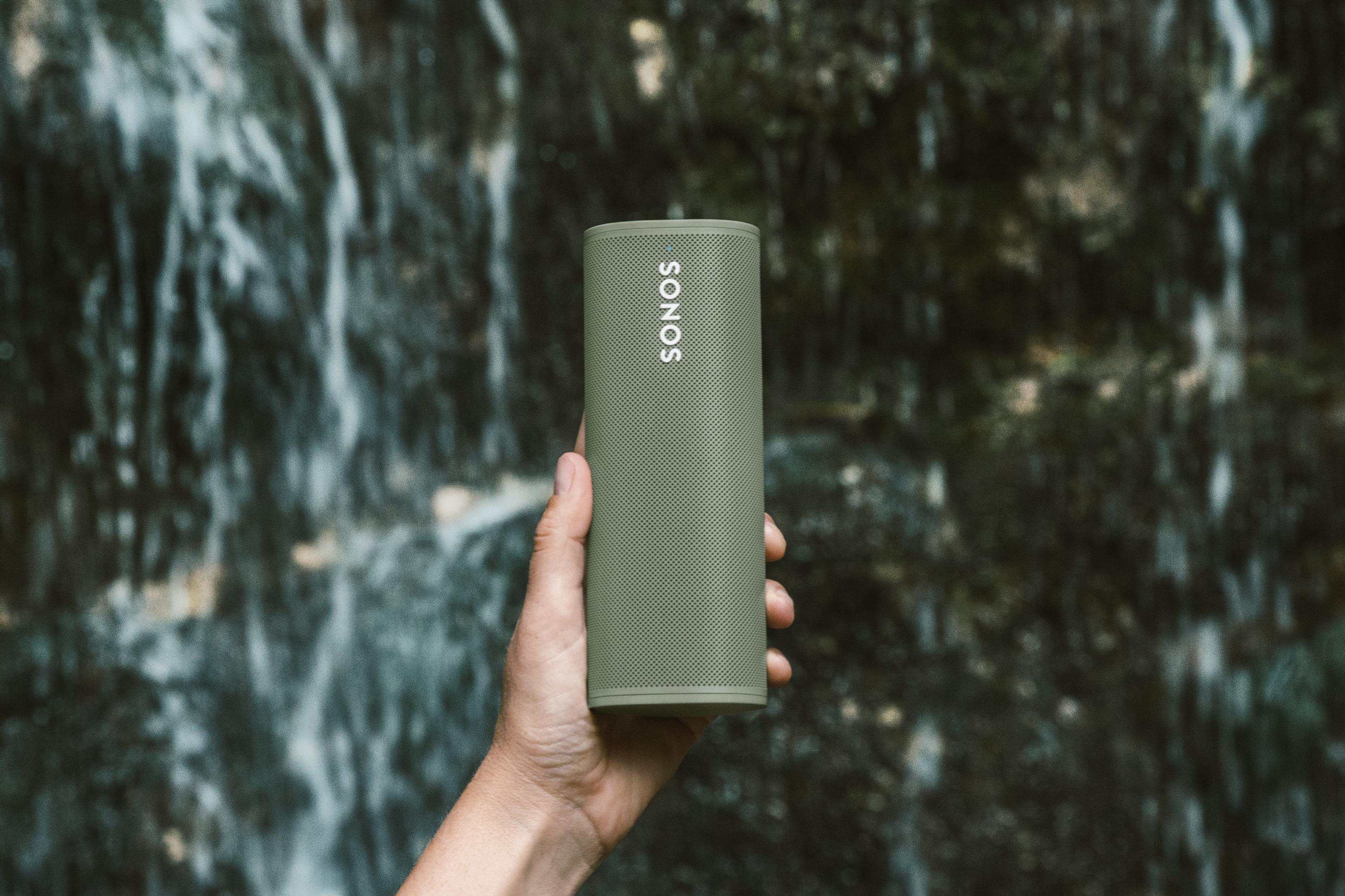 Una bocina Roam en color Olive en uso al aire libre cerca de una cascada