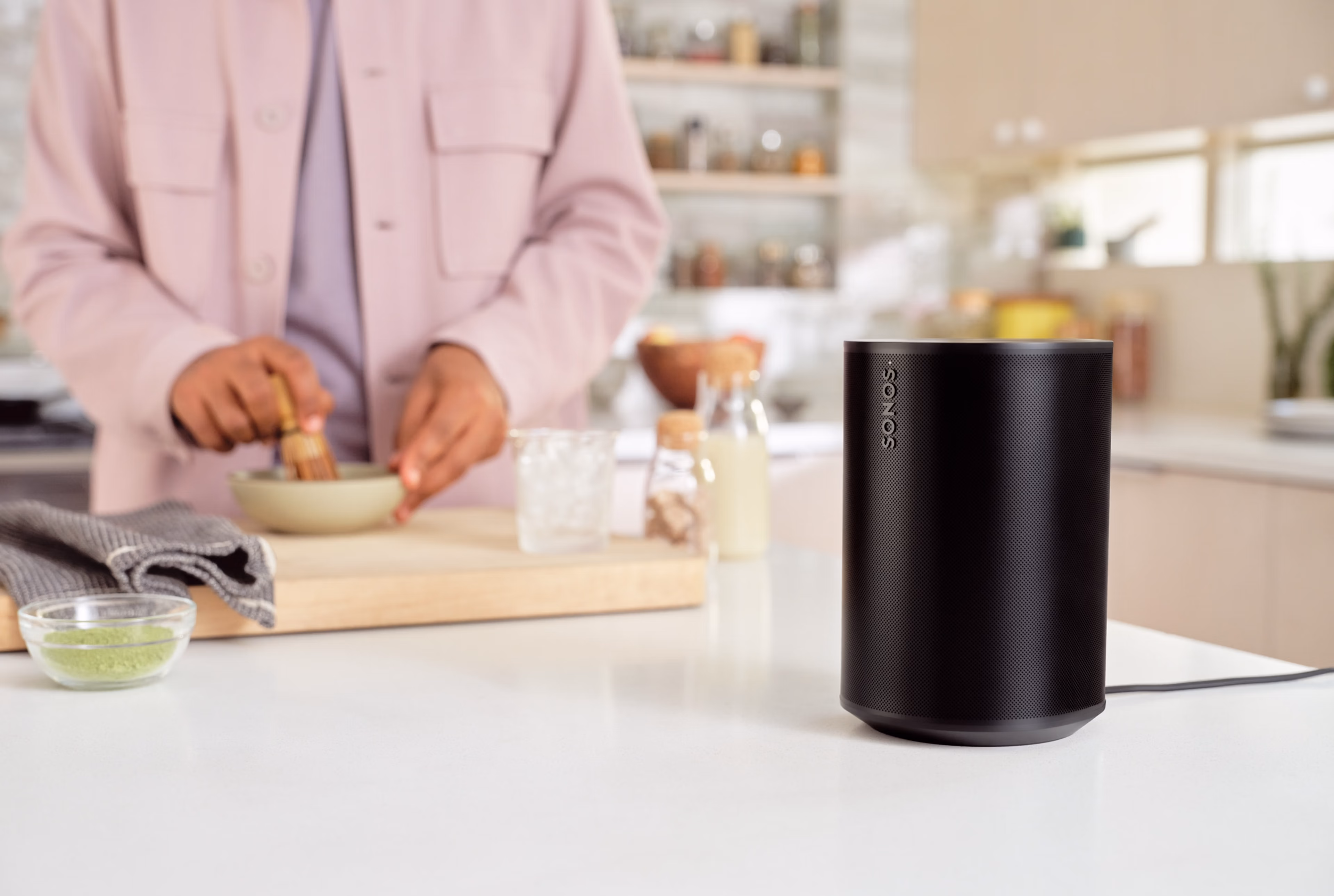 A black Sonos Era 100 sitting on a kitchen countertop